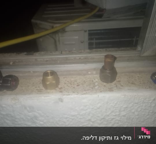 חלקים של מערכת מיזוג אוויר על אדן חלון